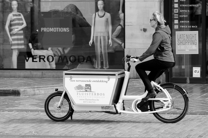 Frau auf einem Lastenfahrrad in der Statd