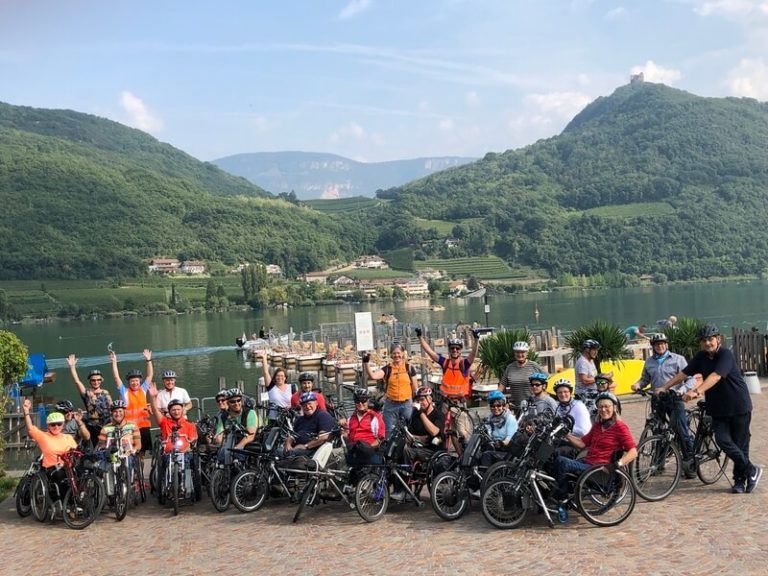 Gruppenbild von Handbikern vor See und Bergen