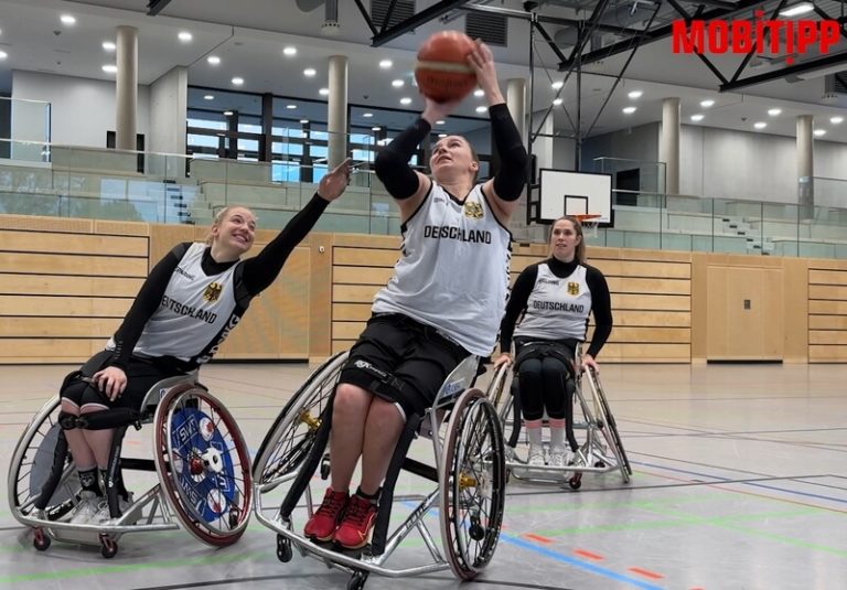 Drei Rollstuhlfahrerinnen in einer Halle beim Basketballspielen