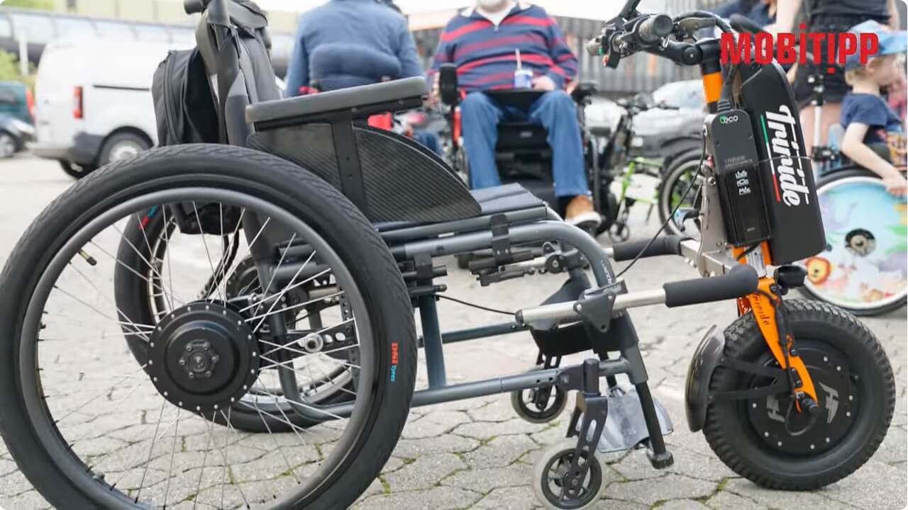 Man sieht einen manuellen Rollstuhl von der Seite mit einem Zuggerät