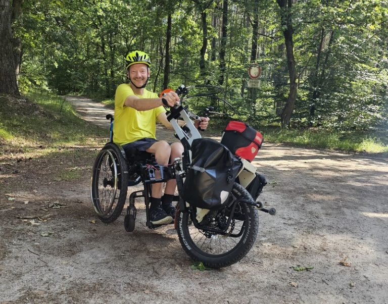 Mann mit Rollstuhl und Handbike im Wald