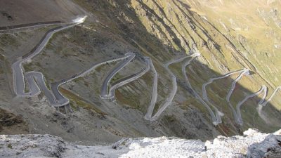 Blick auf eine Serpentinennstraße in den Alpen
